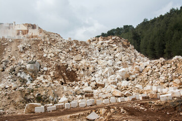 Stone quarry with blocks of stone and dirt road.