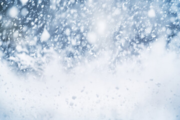 Obraz premium Snow gently falls over a tranquil snowy landscape, creating a serene winter scene. Daylight enhances the beauty of the cold, wintry atmosphere, inviting calmness.