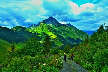 Austrian Alps - view of the Biberkopf mountain and tourists on the path near the village of Warth in the Lechtal Alps