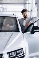 Business man choosing a car in car salon