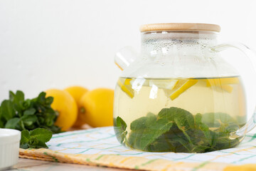 Mint lemon drink in tea pot. Close-up. Copy space.
