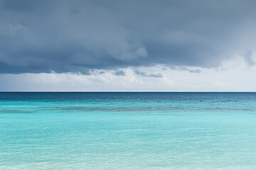 Obraz premium Tranquil turquoise ocean meeting a grey sky