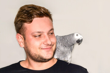 large African parrot sits on the shoulder of a laughing man. man and animals © Tatiana