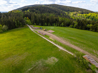 Freshly cut and stacked wood on a meadow near the forests of the Jizera Mountains in the Czech...