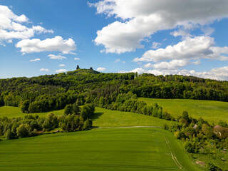 Naklejka premium Aerial view of Trosky Castle with towers Baba and Panna rising above the green landscape of forests and meadows, a famous and popular historical site in the Czech Republic