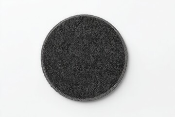 Dark gray round rug on white background. Simple, minimalist design.