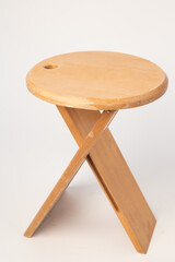 Small, folding, used wooden stool that can also serve as a side table,.
