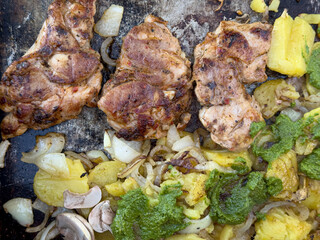 Delicious grilled chicken breast served with roasted potatoes, onions, and pesto.
