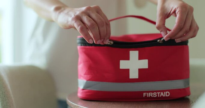 Woman open the first aid kit at home. First aid kit.