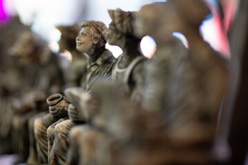 Detailed image of several small, intricately sculpted figurines arranged in a line.  Great for illustrative purposes.