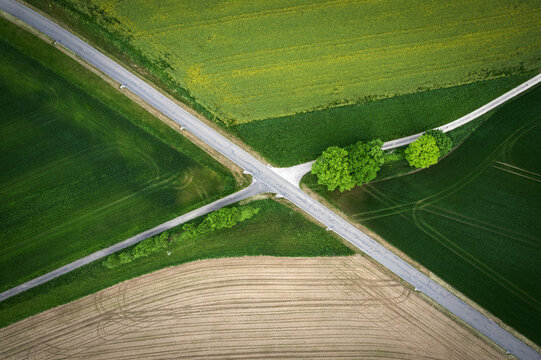 Croisement d'un chemin et d'une route de campagne dans le canton de Vaud en Suisse. Vue de dessus avec un drone