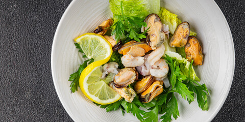 Seafood salad fruit de mer shrimp, mussels, squid, rapawn, prawn, green mixed leaf dish fresh food background on the table rustic food top view copy space keto paleo diet vegetarian pescetarian