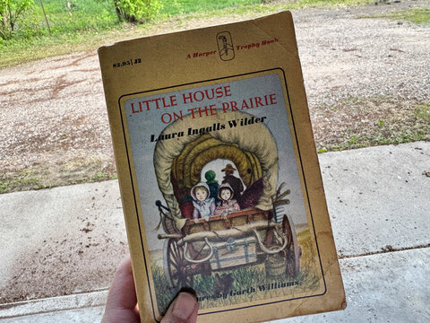 Scandia, MInnesota - May 9, 2025: Hand holds a 1980s edition Little House on the Prairie book from Harper Trophy