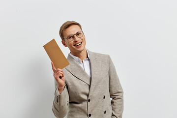 Smiling woman in gray checked blazer holding blank cardboard sign, looking at camera, enthusiastic...