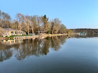Fototapeta premium Lakeshore home with dock in photo on Big Marine Lake, Scandia Minnesota in early spring
