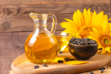 Sunflower oil and sunflower seeds on traditional rustic wooden background. Organic and eco food concept. Healthy food and fats.