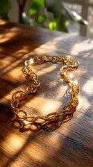 Stunning gold bracelet gracefully resting on a table illuminated by natural sunlight glare