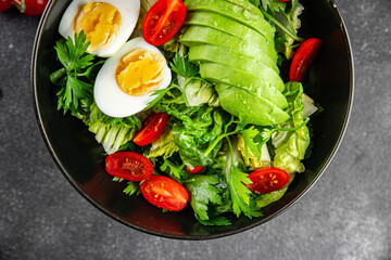 Avocado salad, boiled egg, tomato, green leaf lettuce, vegetable dish fresh delicious gourmet food background on the table rustic food top view copy space keto and paleo diet vegetarian food