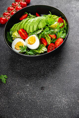 Avocado salad, boiled egg, tomato, green leaf lettuce, vegetable dish fresh delicious gourmet food background on the table rustic food top view copy space keto and paleo diet vegetarian food