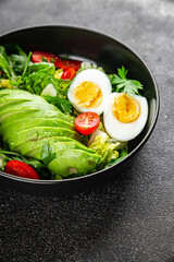 Avocado salad, boiled egg, tomato, green leaf lettuce, vegetable dish fresh delicious gourmet food background on the table rustic food top view copy space keto and paleo diet vegetarian food