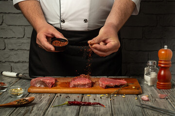 A chef sprinkles spices over fresh cuts of beef on a wooden board. The rustic kitchen ambiance enhances the focus on the cooking process, emphasizing culinary skills and flavors