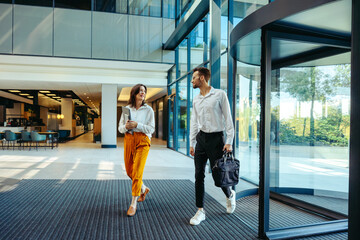 Fototapeta na wymiar Coworkers arriving at modern office building entrance