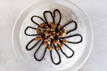 Pancho cake with pineapple and sour cream topped with chocolate and walnut on a light background, closeup. Top view.