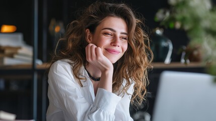 portrait of young beautiful woman smiling while working with laptop in office