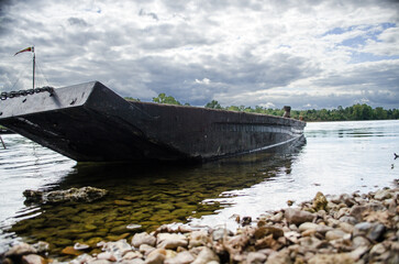 Traditional wooden boat, known as a Gabare, moored on the banks of the Loire River at Montsoreau, France, in a tranquil rural setting. © Jon
