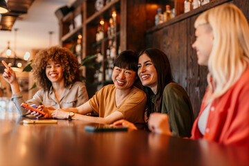 Cheerful female friends enjoying time together in cafe bar