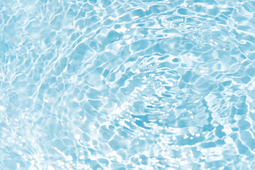 Obraz premium Blue water with ripples on the surface. Defocus blurred transparent blue colored clear calm water surface texture with splashes and bubbles. Water waves with shining pattern texture background.