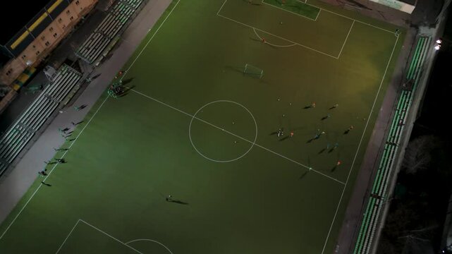 Drone view of night football practice on artificial turf