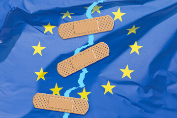 PROBLEMS AND SOLUTIONS OF THE EUROPEAN UNION - Concept with torn European flag patched with...