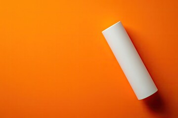 White cylindrical object on vibrant orange background