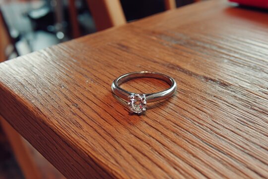 Beautiful engagement ring resting on a wooden table in a cozy indoor setting during a warm afternoon