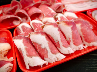 Sliced Meat and belly pork in tray for shabu or Sichuan mala hotpot on restaurant table.