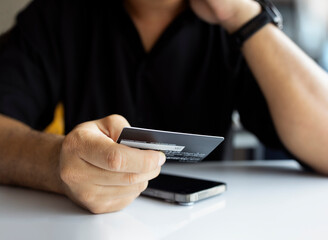 Online Payment with Credit Card on Laptop by Man in Black Shirt
