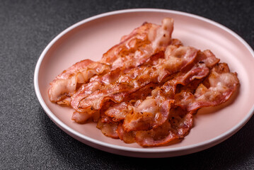 Cooked crispy bacon, slices of roast pork for an English breakfast. Fried bacon