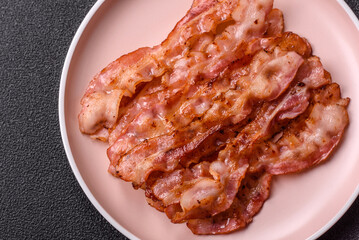 Cooked crispy bacon, slices of roast pork for an English breakfast. Fried bacon