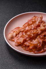 Cooked crispy bacon, slices of roast pork for an English breakfast. Fried bacon