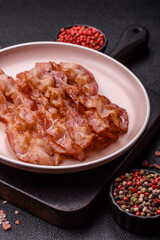 Cooked crispy bacon, slices of roast pork for an English breakfast. Fried bacon
