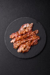 Cooked crispy bacon, slices of roast pork for an English breakfast. Fried bacon