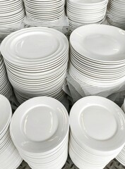 Stacks of clean, white plates ready for use in a commercial setting.