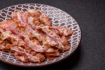 Cooked crispy bacon, slices of roast pork for an English breakfast. Fried bacon