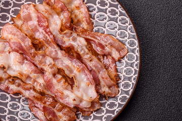 Cooked crispy bacon, slices of roast pork for an English breakfast. Fried bacon