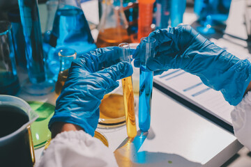 Scientist pipetting medical samples into microplate in laboratory