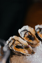 A set of oysters with additional stuffing inside. Sophisticated decor in a restaurant.