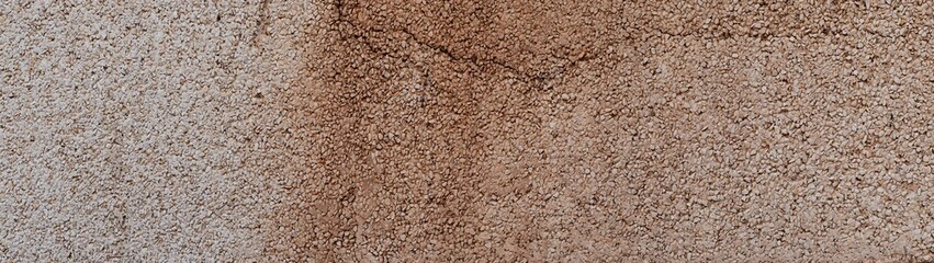 Surface of compacted gray gravel wall with a weathered texture