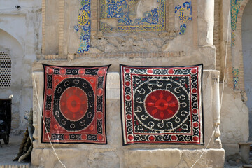 square scarves with bright patterns on the wall of an old building