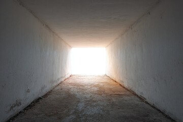 Fototapeta premium Tunnel of Light: An evocative tunnel, bathed in an ethereal glow, beckons with the promise of an escape into the radiant sunlight, creating a scene of hope and anticipation.